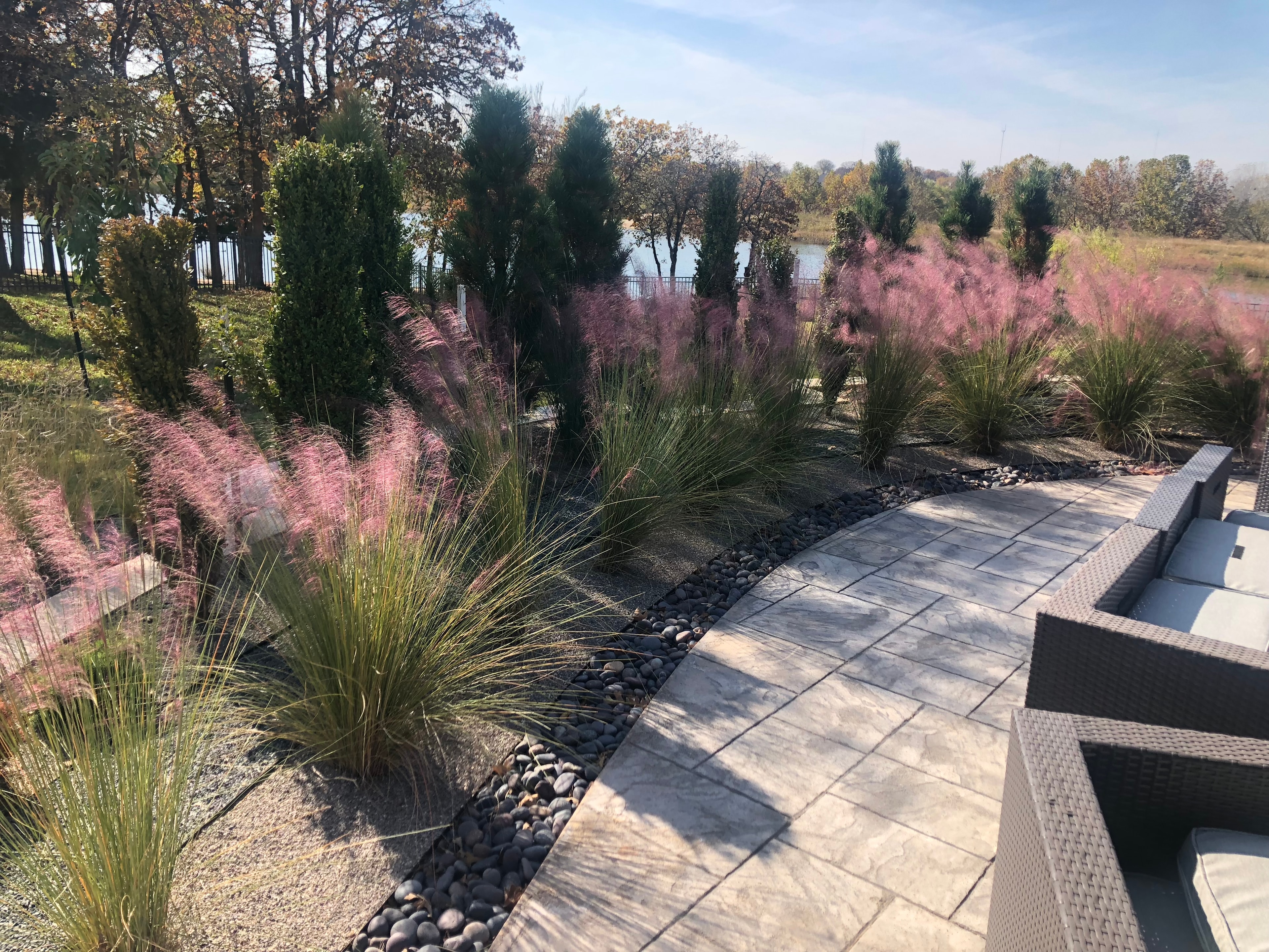 Waterfront garden with ornamental grasses by Studio W