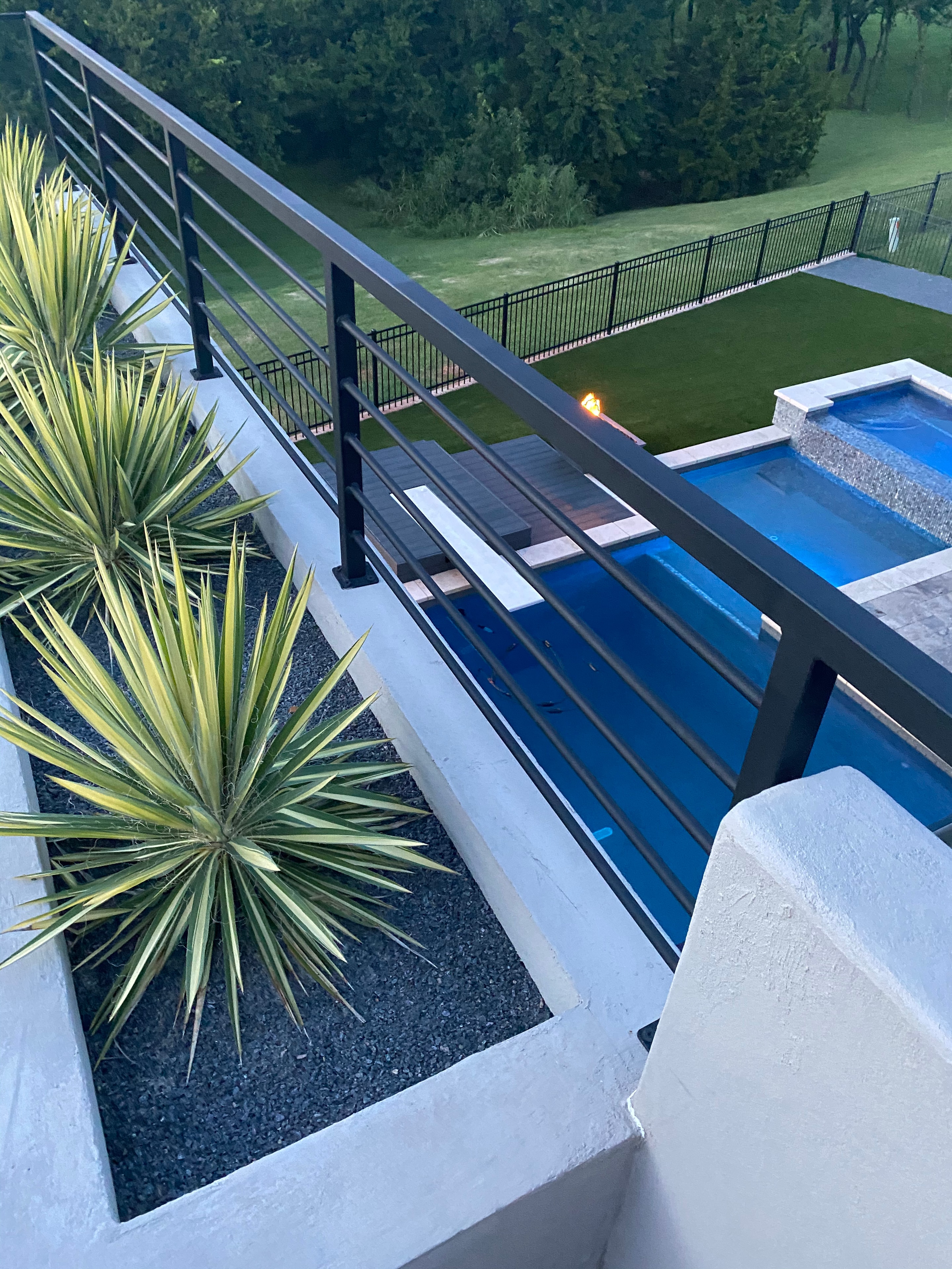 Louvered pergola over brick patio with wicker seating, stone bar, and outdoor living space